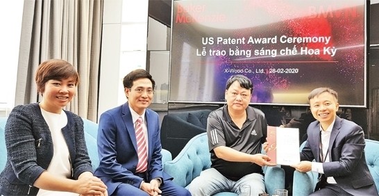 Tran Hoai Nam (third from left) receives a US patent for impregnating wood with polymer solution