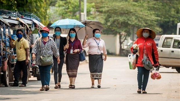 People in Laos wear face masks to prevent SARS-CoV-2. (Photo: VNA)
