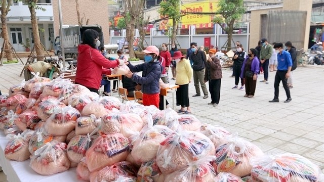 Representatives from People’s Committee of Mai Dong Ward in Hanoi’s Hoang Mai District present food for local households with economic difficulties amid COVID-19 pandemic (Photo: VNA