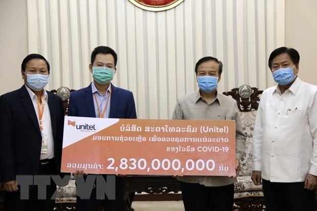 Representatives of Star Telecom present the aid packages worth US$320,000 to the Lao Government. (Photo: VNA)