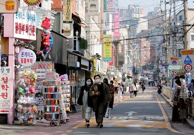 A couple wearing masks to protect against contracting the coronavirus disease walk along a street in Seoul April 3, 2020. ( Source: Reuters)