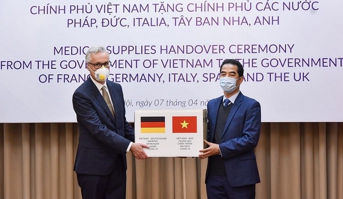 Vietnamese Deputy Foreign Minister To Anh Dung (R) presents medical supplies to the Government and people of Germany on April 7. (Photo: baoquocte.vn)