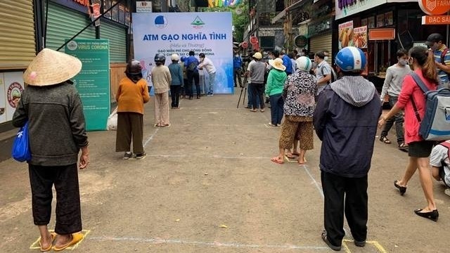 Poor people waiting for their turn to receive rice from the “ATM”.