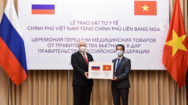 Deputy Foreign Minister To Anh Dung (R) presents the aid to Russian Ambassador Konstantin Vnukov. (Photo: MOFA)
