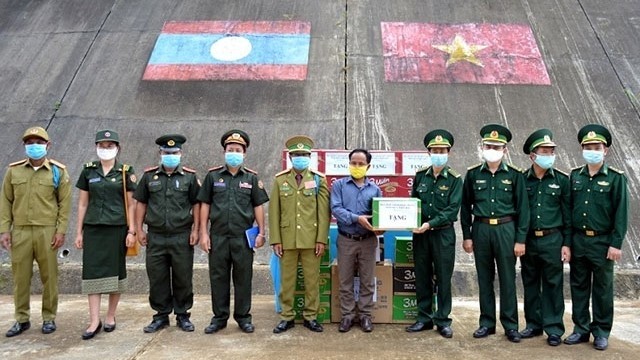 Leaders of the provincial Border Guard High Command present gifts to the armed forces and people in Kalo Village of Sekong Province. (Photo: NDO)