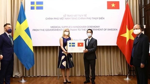 Deputy Foreign Minister To Anh Dung (R) symbolically presents the medical supplies to Swedish Ambassador to Vietnam Ann Mawe (Photo: VNA)