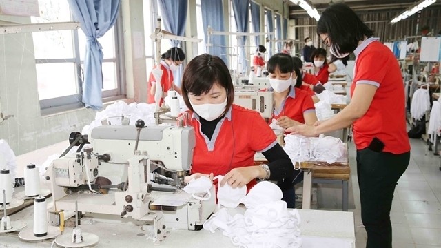 Workers at Chien Thang Garment Joint Stock Company produces cloth face masks. The COVID-19 pandemic was bringing significant opportunities for Vietnam to export face masks. (Photo: VNA)