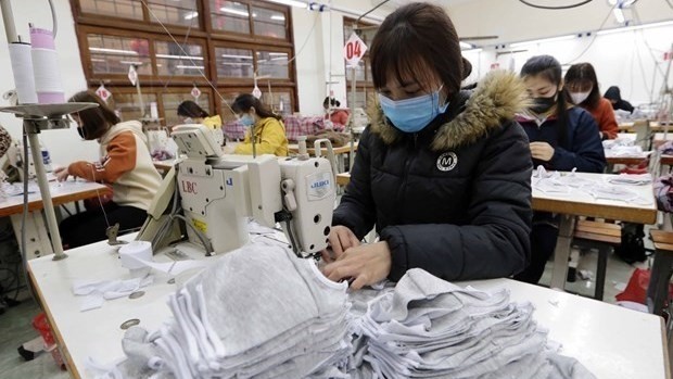Workers produce garment products for export (Photo: VNA)
