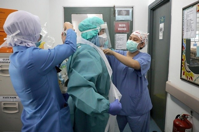 Nurses help each other to put on a protective equipment before entering the coronavirus disease (COVID-19) ward at Kuala Lumpur Hospital, in Kuala Lumpur, Malaysia, April 21, 2020. (File photo: Reuters)