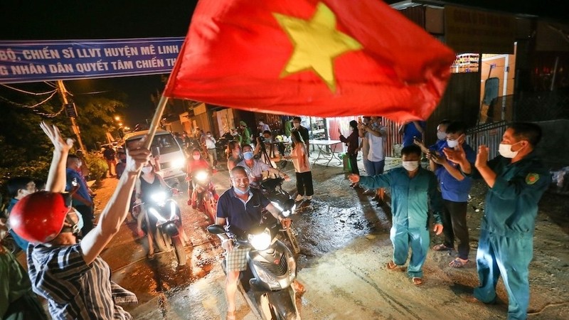 Ha Loi villagers happily hold the national flag at the moment the quarantine orders were lifted.