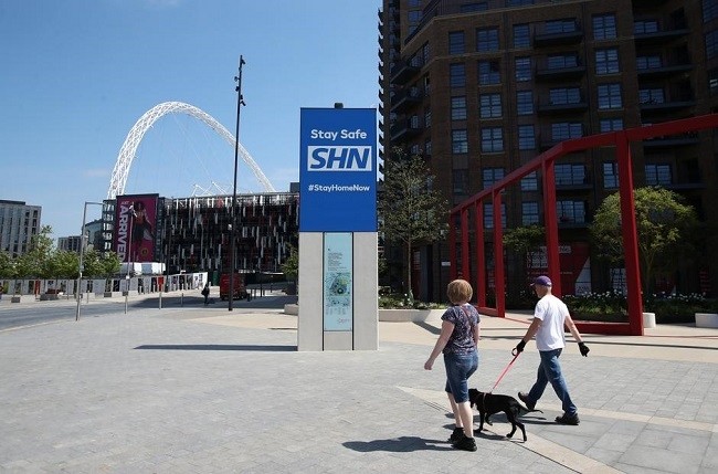 A public health campaign message is seen as people walk a dog outside Wembley Stadium, following the outbreak of the coronavirus disease (COVID-19), London, Britain, May 7, 2020.  Prime Minister Boris Johnson will announce a very limited easing of Britain’s coronavirus lockdown next week, adopting a cautious approach to try to ensure there is no second peak of infections that could further hurt the economy. (Photo: Reuters)