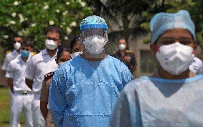 The staff of INHS Asvini hospital wearing protective gear stand before they were showered with flower petals by Indian Navy's Chetak helicopter as part of an event to show gratitude towards the frontline warriors fighting the coronavirus disease (COVID-19) outbreak, in Mumbai, India, May 3, 2020. (Photo: Reuters)