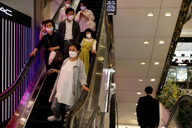 People wearing masks to avoid the spread of the COVID-19 ride on an escalator at a department store in Seoul, ROK, May 1, 2020. (Photo: Reuters)