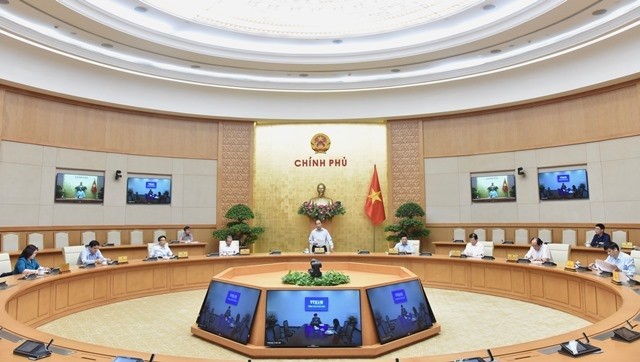 Prime Minister Nguyen Xuan Phuc (standing) delivers his speech at an online cabinet meeting on COVID-19 control, held at Government headquarters in Hanoi on May 15, 2020. (Photo: NDO/Tran Hai)