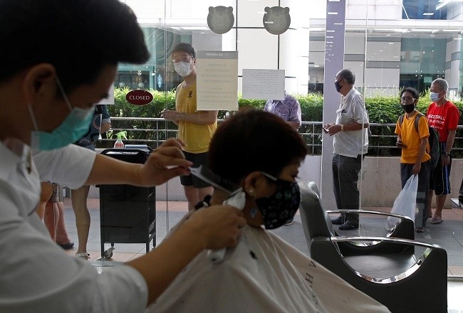 Customers queue up to have their haircut outside a hairdressing salon as they reopen for business amid the coronavirus disease (COVID-19) outbreak in Singapore May 12, 2020. (Photo: Reuters)