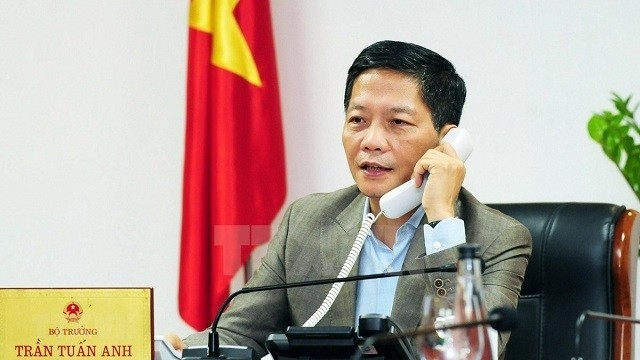 Minister of Industry and Trade Tran Tuan Anh talks on the phone. (Photo: VNA)