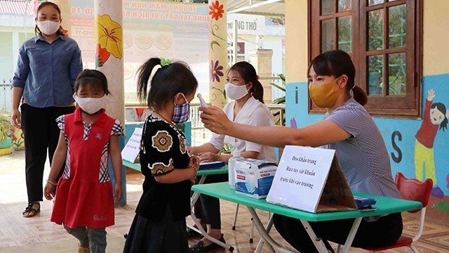 Children at Mu Sang Kindergarten in Phong Tho District, Lai Chau Province have their temperatures checked as the facility reopening after the three-month break due to the coronavirus pandemic. (Photo: NDO/Tran Tuan)