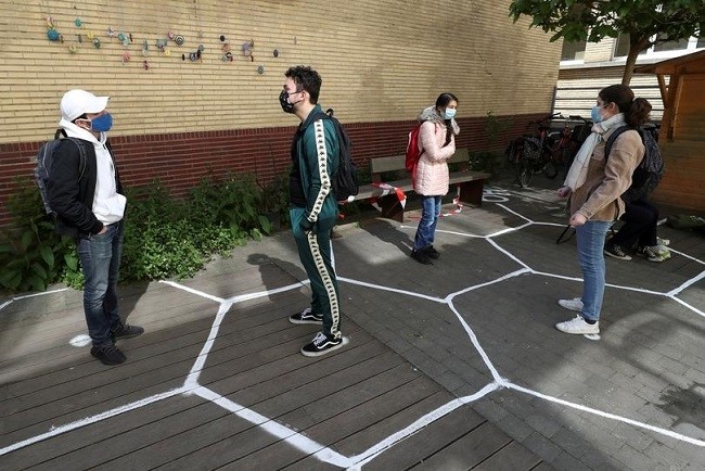 Students talk while practicing social distancing at the courtyard of a secondary school during its reopening in Brussels, Belgium, May 15. (Photo: Reuters)