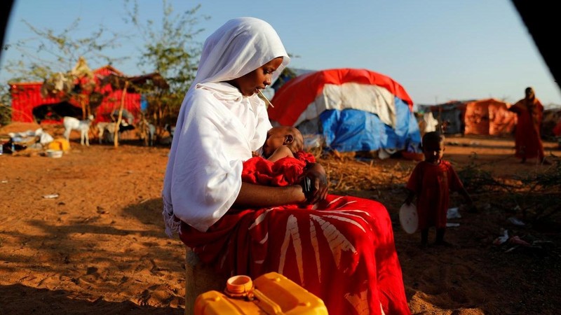 Zeinab, 14, sits as she holds her nephew at a camp for internally displaced people from drought-hit areas in Dollow, Somalia. (Photo: Reuters)