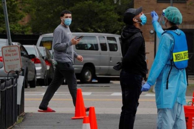 A pedestrian watches as a man is tested for the coronavirus disease (COVID-19) in Boston, Massachusetts on May 18. (Photo: Reuters)