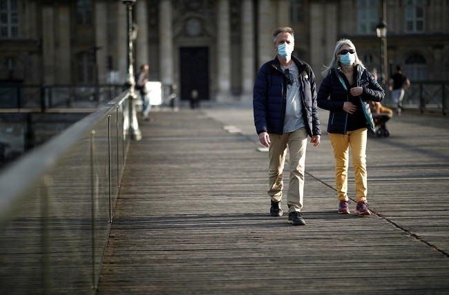 People wearing protective masks walk at the Pont des Arts bridge during the outbreak of the coronavirus disease (COVID-19) in Paris, France, May 2, 2020. (File photo: Reuters)
