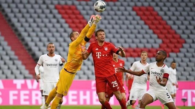 Soccer Football - Bundesliga - Bayern Munich v Eintracht Frankfurt - Allianz Arena, Munich, Germany - May 23, 2020  Bayern Munich's Thomas Muller in action with Eintracht Frankfurt's Kevin Trapp, as play resumes behind closed doors following the outbreak of the coronavirus disease. (Photo: Reuters) 