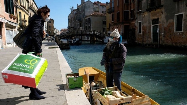 A man delivers fruits and vegetables by boat to customers’ houses in Venice. Italy is among those calling for the issuance of joint European debt. (Photo: Reuters)