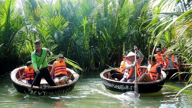 Visitors on boats to explore Bay Mau coconut forest in Hoi An city (Photo: zing.vn)
