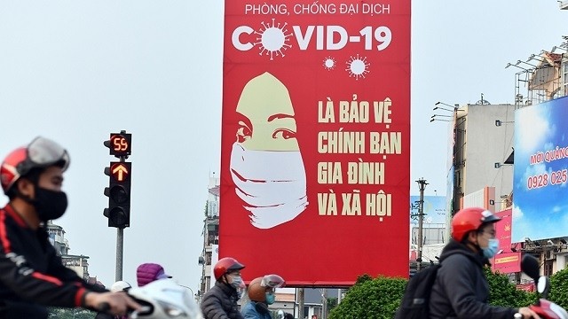 A poster calling for COVID-19 prevention and control placed at an intersection in Hanoi. (Photo: NDO)