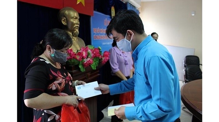 An official from the Ho Chi Minh City Labour Confederation presents financial support to a disadvantaged preschool teacher in District 8 on March 31, 2020. (Photo: NDO/Quy Hien)
