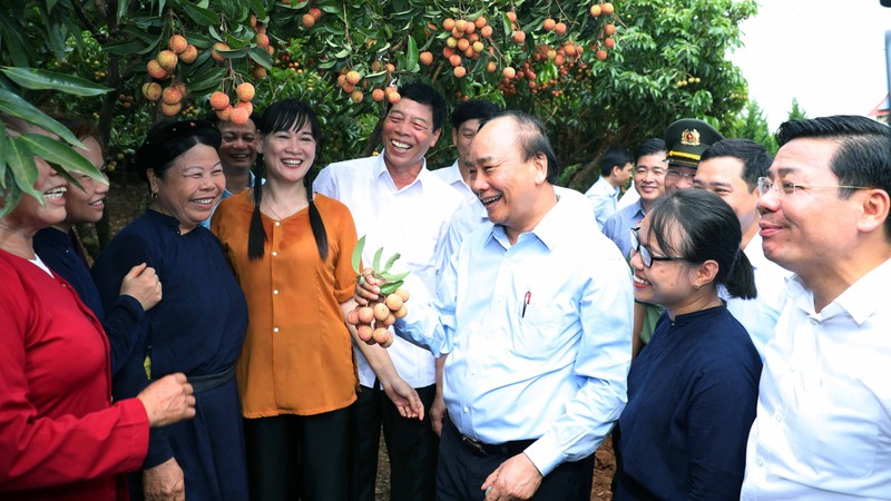 PM Nguyen Xuan Phuc talking with officials, employees and local people at the Uncle Ho fruit garden. (Photo: VGP)
