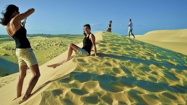 Foreign visitors explore sand dunes in Binh Thuan province before COVID-19 broke out (Photo: VNA)