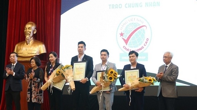 Enterprises honoured with the High-Quality Vietnamese Goods title at the seminar. (Photo: NDO/An Ha)