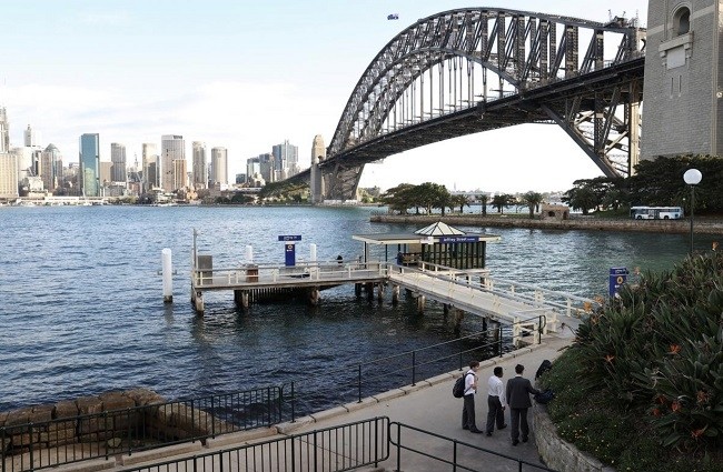 Students wait for a commuter ferry under the Sydney Harbour Bridge amidst the easing of the coronavirus disease (COVID-19) restrictions in Sydney, Australia, May 20, 2020. (Photo: Reuters)