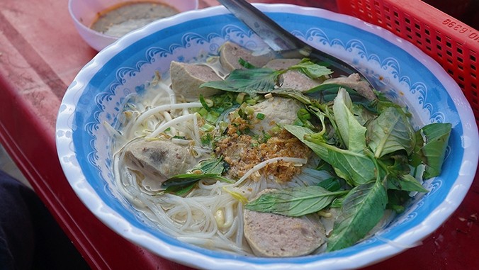 A bowl of meatball noodle soup with fresh herbs on top. (Photo: VnExpress/Phong Vinh)
