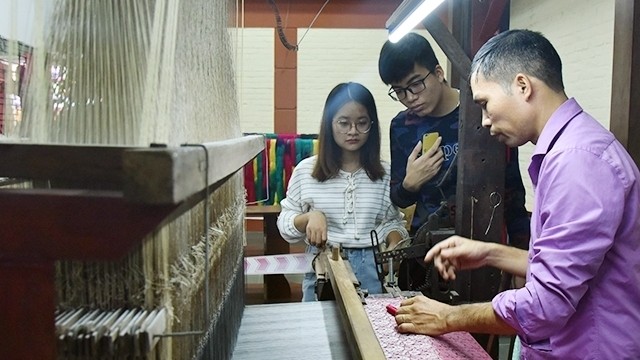 Visitors learning the production of traditional silk in Van Phuc Silk Village (Photo: Dang Anh)