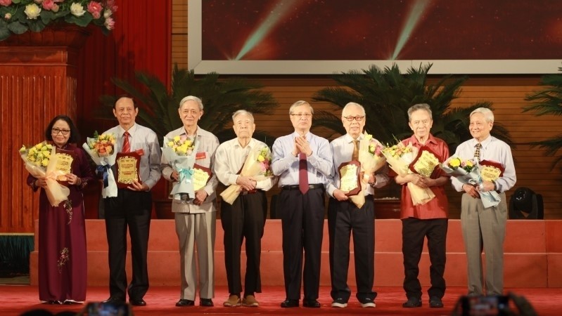 Politburo member Tran Quoc Vuong presents flowers to veteran journalists at conference held in Hanoi on June 13 as part of activities to mark the 95th anniversary of Vietnam Revolutionary Press Day.