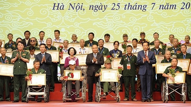 Prime Minister Nguyen Xuan Phuc and representatives of seriously injured war veterans at a gathering in Hanoi in July 2019. (Photo: NDO/Dang Khoa)