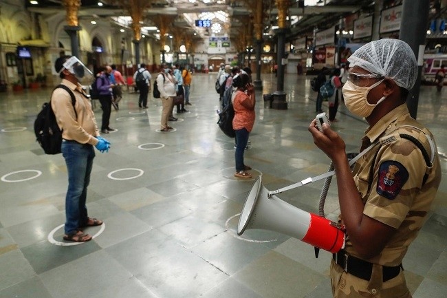  A railway police official makes an announcement on a loudspeaker telling commuters to stand inside the designated circles to maintain social distancing as they wait to board a train at a railway station after some restrictions were lifted during a lockdown to slow the spread of the coronavirus disease (COVID-19) in Mumbai, India, June 22, 2020. (Photo: Reuters)