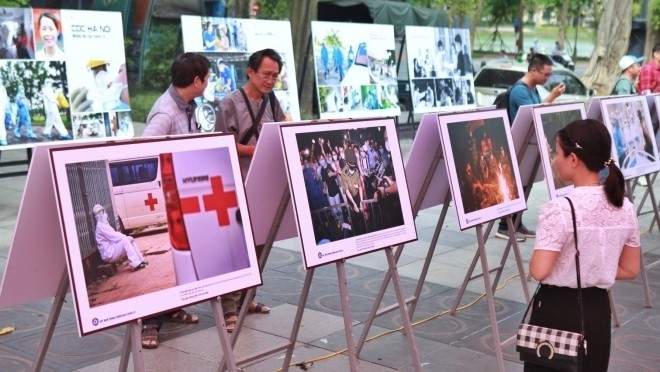 Visitors admiring photos on display at the exhibition (Photo: VNA)