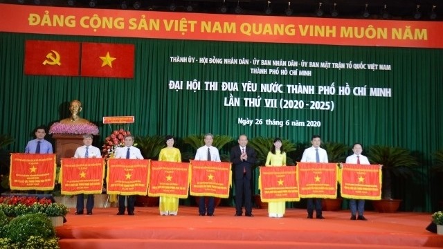 Deputy PM Truong Hoa Binh presents the Government's Emulation Flag to eight collectives of Ho Chi Minh City at the event. (Photo: NDO/Manh Hao)