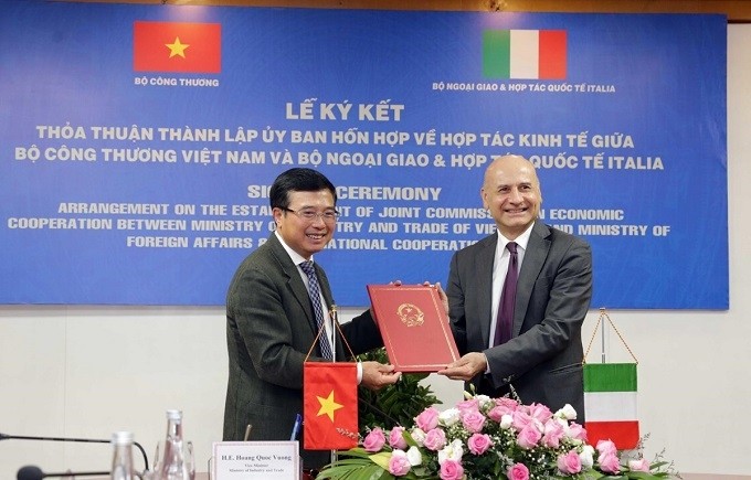Deputy Minister of Industry and Trade Hoang Quoc Vuong (L) hands over the signed agreement to Italian Ambassador to Vietnam Antonio Alessandro. (Photo: VNA)