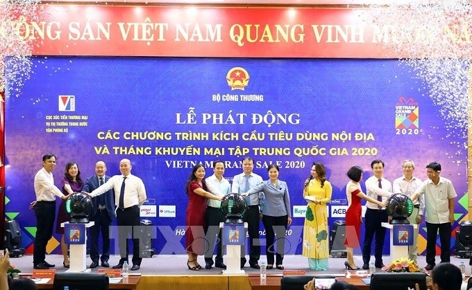 Delegates perform the ritual to launch domestic consumption stimulus programmes and a concentrated national promotion month on July 1. (Photo: VNA)
