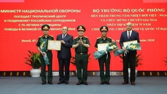 Defence Minister Ngo Xuan Lich presents certificates of merit to the centre and its leaders. (Photo: NDO/Linh Phan)