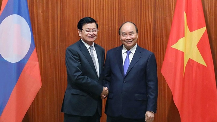 PM Nguyen Xuan Phuc (R) and Lao PM Thongloun Sisoulith. (Photo: VNA)