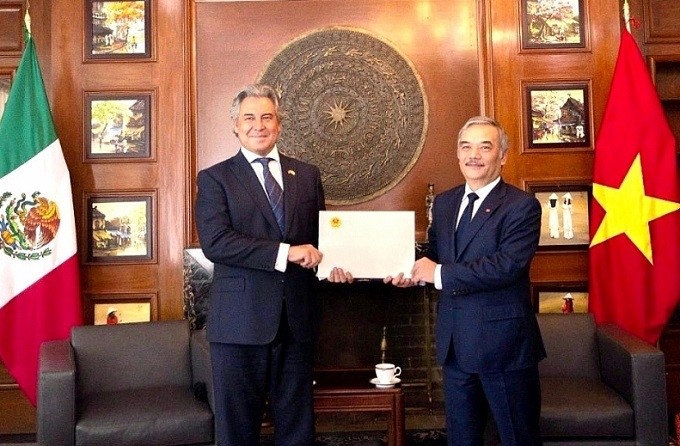 Vietnamese Ambassador to Mexico Nguyen Hoai Duong (R) hands over the decision to Miguel Angel Landeros Voquart, Vice President of the Mexican Business Council for Foreign Trade. (Photo: Baoquocte.vn)