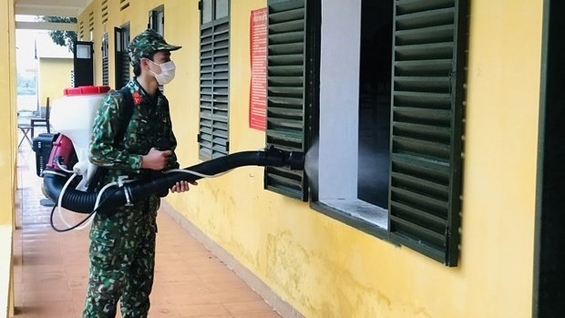 A soldier is spraying chemical to disinfect thoroughly the environment and related areas in order to contain the spread of COVID-19 (Photo: VNA)