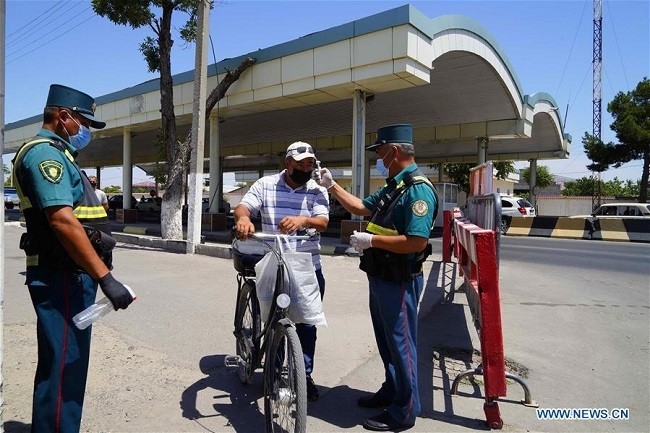 A police officer checks the body temperature of a man entering Tashkent in a street in Tashkent, Uzbekistan, July 10, 2020. Uzbekistan has announced to introduce a second lockdown from July 10 to Aug. 1 in an effort to prevent the spread of the coronavirus. (Photo: Xinhua)