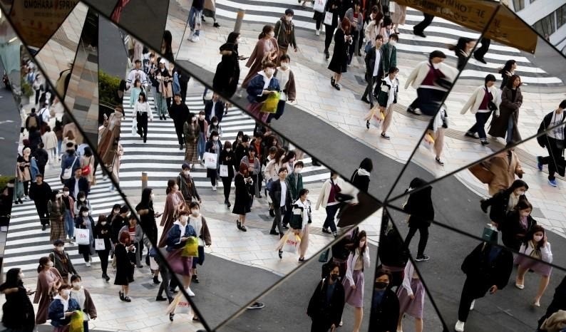 Passersby wearing protective face masks, following an outbreak of the coronavirus disease (COVID-19), are reflected in mirrors at a shopping center in Tokyo, Japan March 26, 2020. (Photo: Reuters)