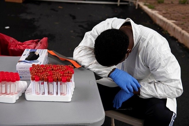 Overheated, a healthcare worker takes a break as people wait in their vehicles in long lines for the coronavirus disease (COVID-19) testing in Houston, Texas, US, July 7, 2020. (File photo: Reuters)